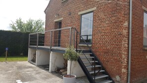 Un edificio de ladrillo con una escalera metálica que lleva a una plataforma.