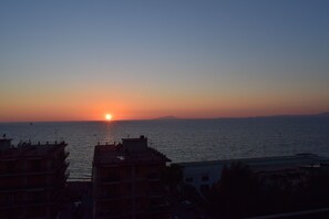 Una vista al atardecer sobre una masa de agua, con edificios al frente.