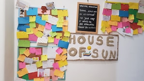 Un tablón de anuncios con notas de colores y un letrero que dice 'HOUSE OF SUN'.