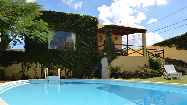 A swimming pool with a wooden deck and a lounge chair. - Chalet La Alpispa with private pool in Las Palmas. (Las Palmas de Gran Canaria)