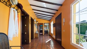 A corridor with tiled flooring, wooden doors, and a bench. - Chalet La Alpispa with private pool in Las Palmas. (Las Palmas de Gran Canaria)