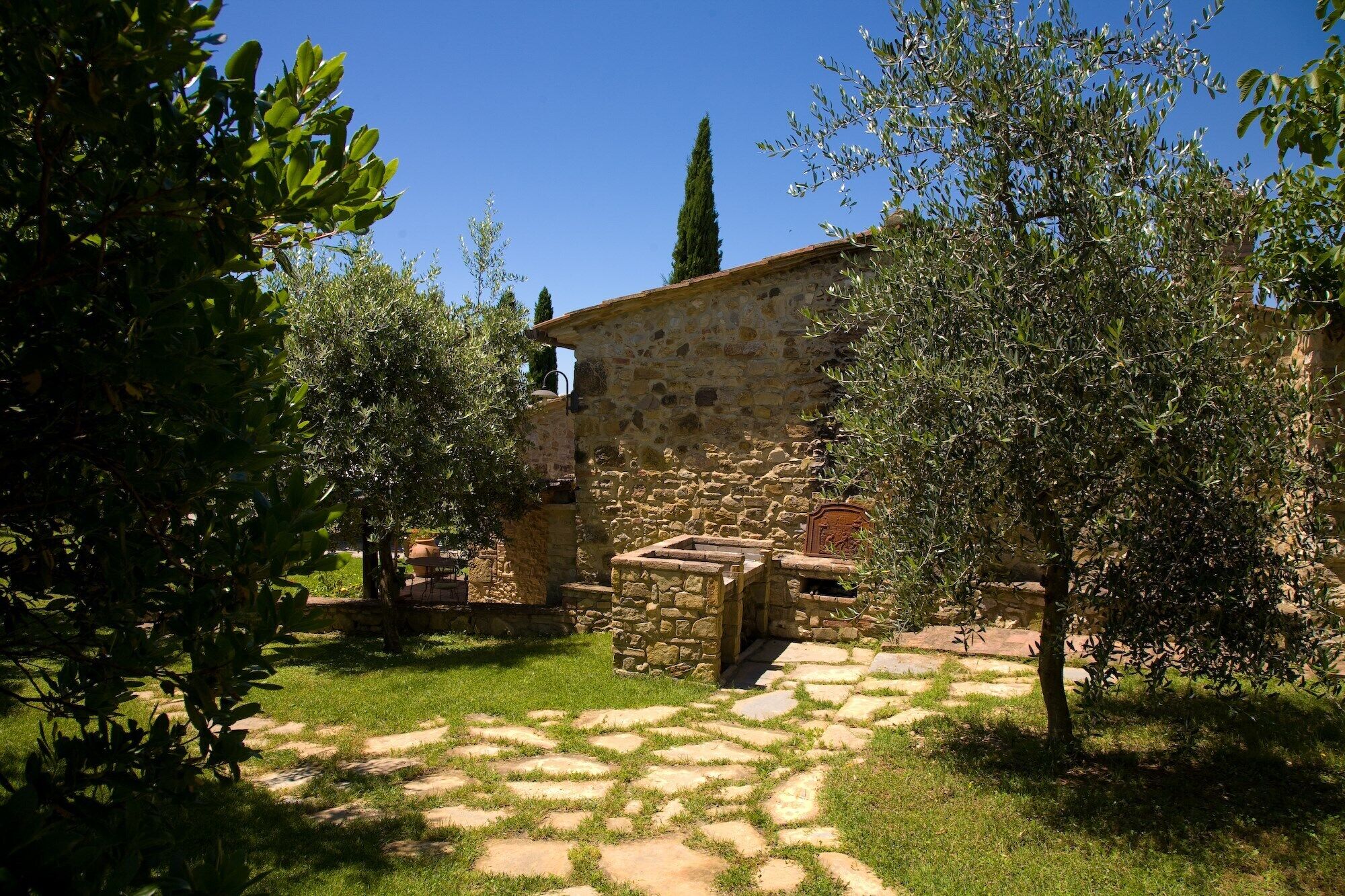 Un bâtiment en pierre, doté d’un mur en pierre rustique et d’une petite structure en bois à l’avant.