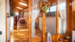 A wooden cabin interior with a cozy living area, a kitchen, and a dining space. - Comfortable and bright apartment with terrace just 300 meters from the sea (Quartu Sant'Elena)