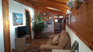 Cozy cabin with a comfortable living area, TV, and seating options.
