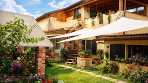 A two-story house with a wooden staircase, outdoor seating, and potted plants. - Comfortable and bright apartment with terrace just 300 meters from the sea (Quartu Sant'Elena)