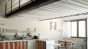Eine moderne Küche mit einer gestreiften Kücheninsel, weißen Schränken und einem Fenster mit Vorhängen.