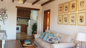 A living room with a sofa, coffee table, and framed pictures on the wall. - APARTMENT LA FINCA (MÁCHER)