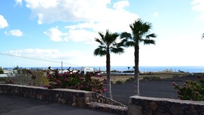 A coastal view with palm trees and a stone wall. - APARTMENT LA FINCA (MÁCHER)