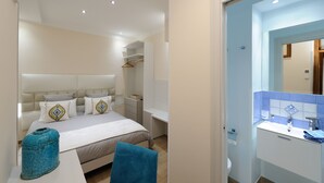 A modern bedroom with a bed, bedside tables, a wardrobe, and a bathroom with a sink and mirror. -  LEMON IN THE AIR  (Pontone)