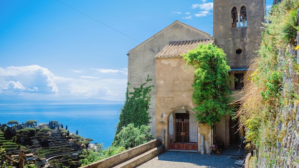 A coastal building with a bell tower, a stone staircase leading to a door, and a view of the sea. -  LEMON IN THE AIR  (Pontone)