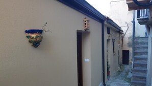 A narrow alleyway with a potted plant on the left and a staircase on the right. - Casa Annunziata Badolato, Borgo, Mare and Olive Harvest (Badolato)