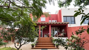 A two-story building with a red facade, a porch with steps, and potted plants. - Casa El Tonelero with garden and private pool (Gáldar)