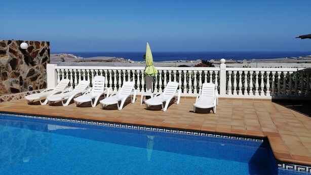 A pool area with lounge chairs and a view of the ocean. - Casa El Tonelero with garden and private pool (Gáldar)
