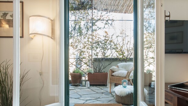Un intérieur moderne avec une porte vitrée donnant sur un patio en pierre.