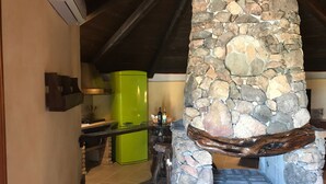 A rustic kitchen with a stone fireplace, a green refrigerator, and a wooden countertop. - Sardinian style holiday home (Quartu Sant'Elena)