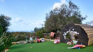 A small, enclosed play area with a wooden structure, a small table, and a few toys. - Sardinian style holiday home (Quartu Sant'Elena)