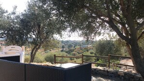 A wicker outdoor seating area with a view of a hilly landscape. - Sardinian style holiday home (Quartu Sant'Elena)