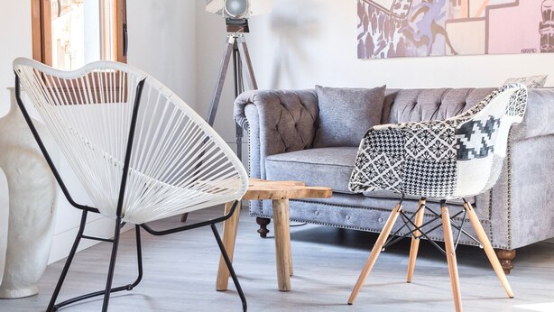 A living room with a grey sofa, a white woven chair, and a small wooden table. - ~SILVER~ by myhomeintoledo.com (Toledo)