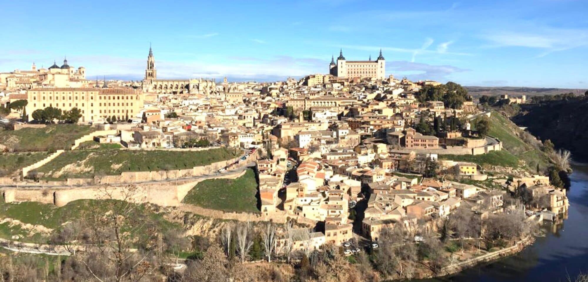 Una vista panoramica di una città storica con un'imponente cattedrale, un castello e un fiume.