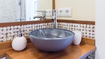 Een bad/douchecombinatie, een haardroger, handdoeken