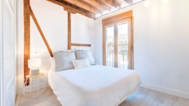 A bedroom with a bed, a small bedside table with a lamp, and a view of the outside through a glass door. - ~SILVER~ by myhomeintoledo.com (Toledo)