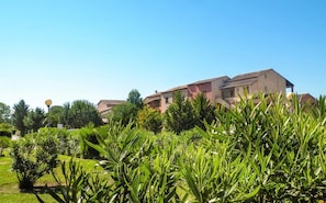 A building with multiple stories, surrounded by lush greenery and trees.