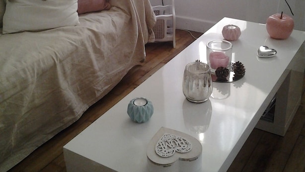 A neatly arranged bedroom with a bed, bedside table, and a TV on a stand.