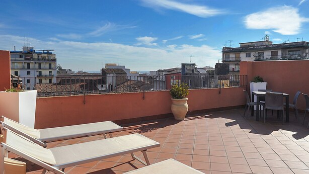 A rooftop terrace with sun loungers, a table, and chairs. - Katane Holidays "Verdi Apartment with Triple Room" (Catania)