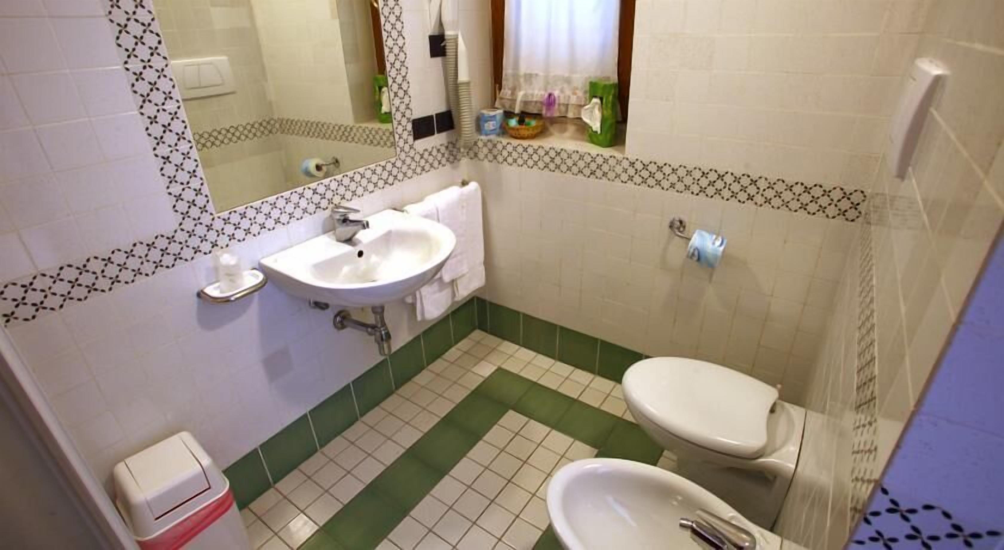 Un baño con lavamanos, inodoro y bidé.
