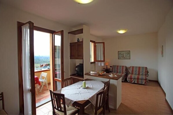 Enjoy meals at the dining table for four, with a kitchenette featuring a stove and sink nearby.