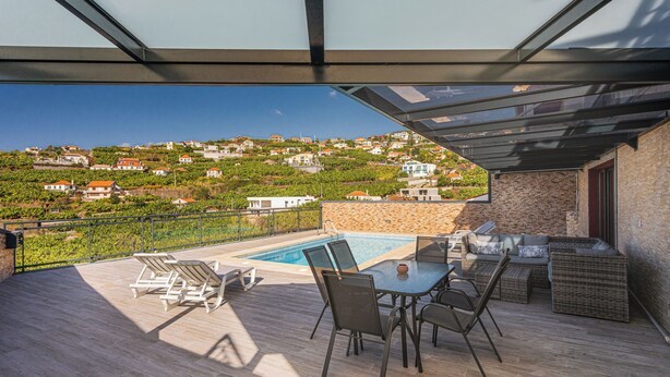 A rooftop terrace with a pool, outdoor furniture, and a view of a hillside town. - New Casa Bondi by Your Madeira Rentals (Ponta do Sol, Madeira Island)