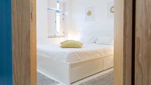 Ein Schlafzimmer mit Bett, Fenster und Tür.