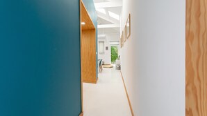 Ein moderner Flur mit blauer Wand, Holzakzenten und gerahmten Bildern an der Wand.