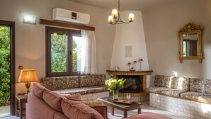 En stue med pejs, to sofaer, et sofabord og en lysekrone.