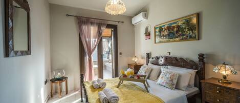 A hotel room with a bed, bedside table, lamp, and a painting on the wall.