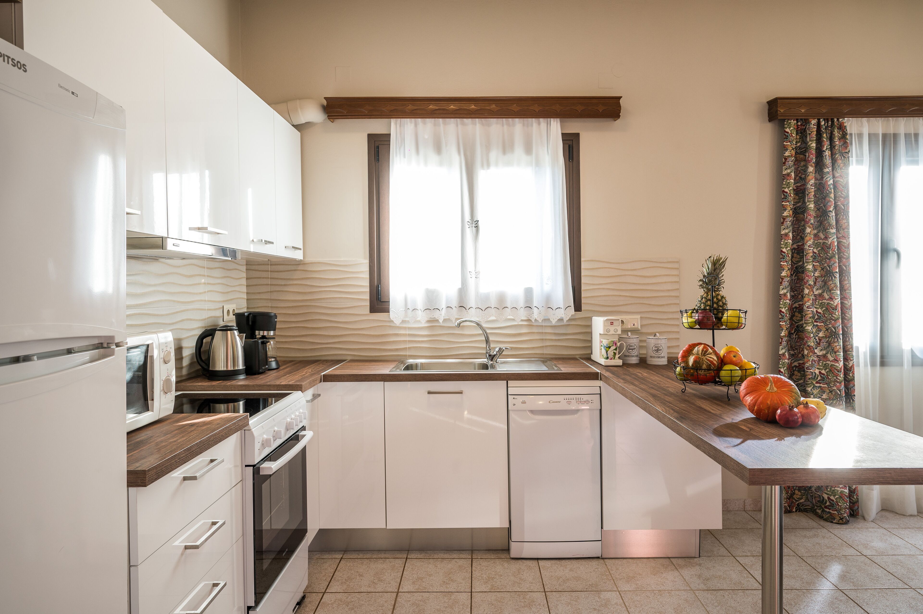 A modern kitchen with white appliances, a wooden countertop, and a sink.