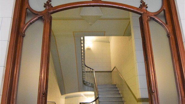 Una escalera con estructura de madera y barandilla de metal.