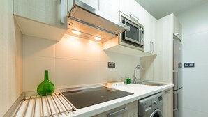 Una cocina moderna con horno empotrado, microondas y refrigerador de acero inoxidable.