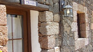 A stone building with a wooden door and a sign reading "TRICO". - "TRIGO" quaint studio apartment in an old mill from the year 1912. (Maguez)
