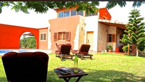 A house with a swimming pool, outdoor seating, and a well-maintained lawn. - Villa Nido Cari—Fuerteventura Rural Oasis (Casillas de Morales)