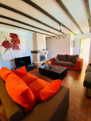 Una sala de estar con chimenea, televisión y sofá.