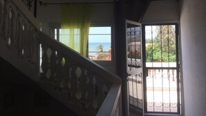 A staircase with ornate railings leading to a balcony with a view of the sea. - Beachfront accommodation Yene - Senegal (Yene Kao)