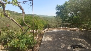 A stone pathway leading to a rustic wooden structure with a metal pergola. - Casa del Vento in San Cono, ancient stone dwelling among olive trees (Polizzi Generosa)