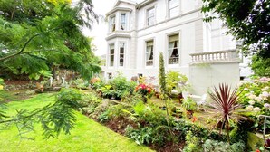 Un bâtiment blanc avec un jardin devant.