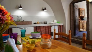 Eine Küche mit einem Holztisch, bunten Schüsseln und einer Vase mit Blumen.