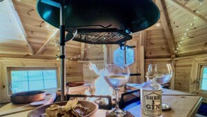 Interior de madera con una mesa dispuesta para comer, una botella de ginebra Shard 1 y un candelabro.