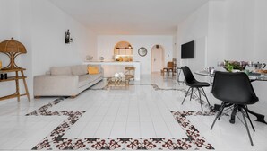 Una sala de estar moderna con un sofá, una mesa de centro y una zona de comedor.