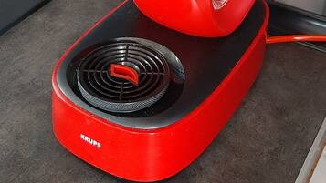 Una cafetera roja Nespresso Dolce Gusto sobre la encimera de la cocina.