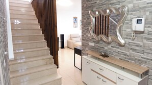 A modern kitchen with a stone backsplash, a built-in bench, and a staircase with wooden railings. - Beautiful and luxurious villa with heated pool and free Wi-Fi in Playa Blanca.  (Yaiza)