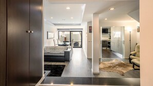 A modern living room with a sofa, a coffee table, and a rug. There is a door leading to another room.